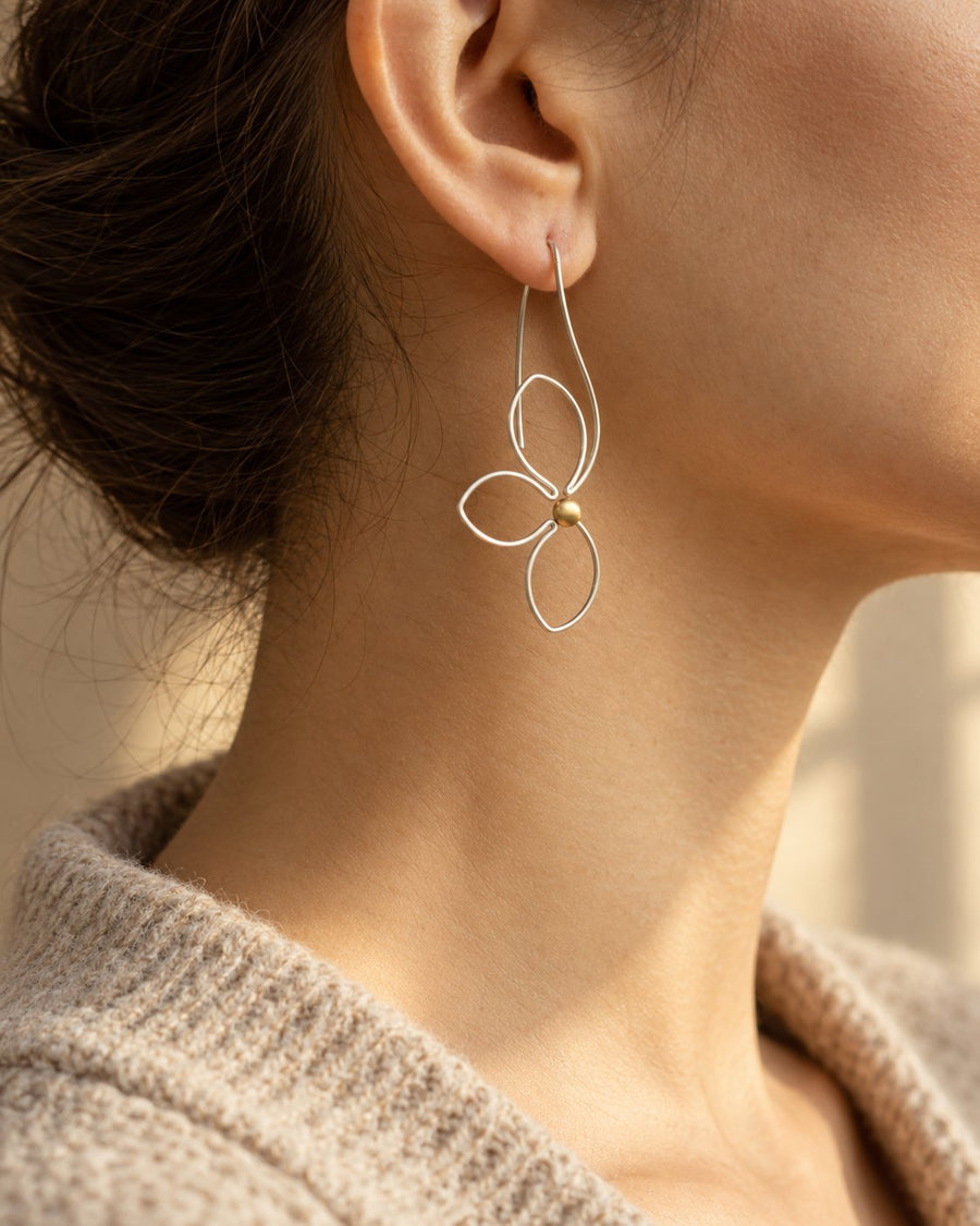 Silver flower wire earring with a pearl worn on the ear