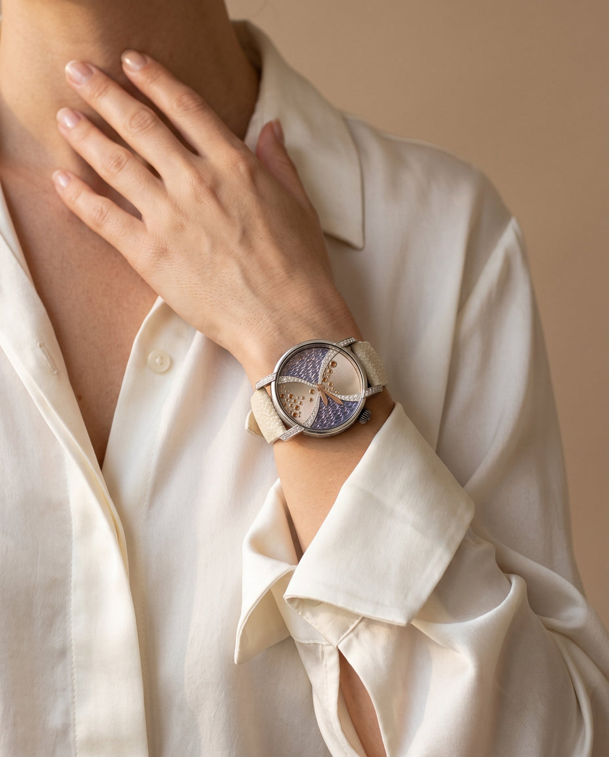 Aurelliani hourglass enamel watch with cream stingray strap worn on a woman's wrist
