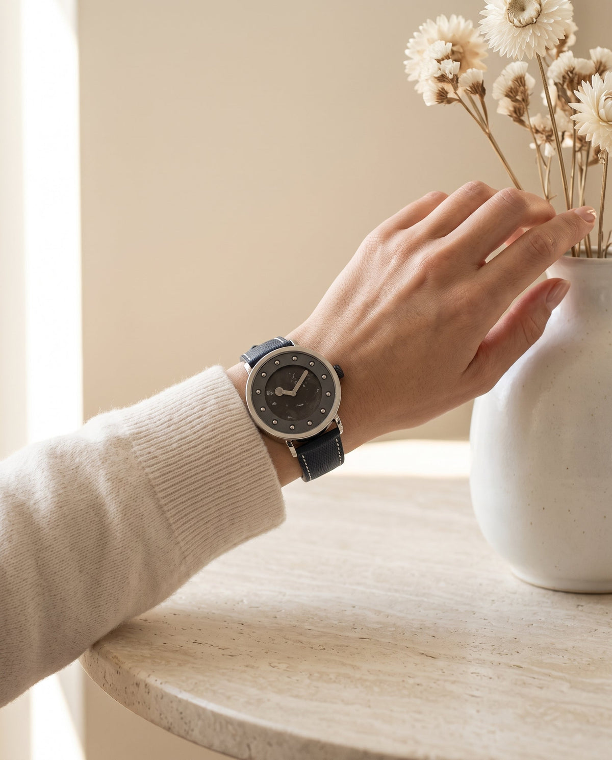 Aurelliani silver watch with twelve stud markers worn on a woman's wrist