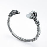 Silver eagle cuff with an eagle head on one end and a talon holding raw rock crystal on the other