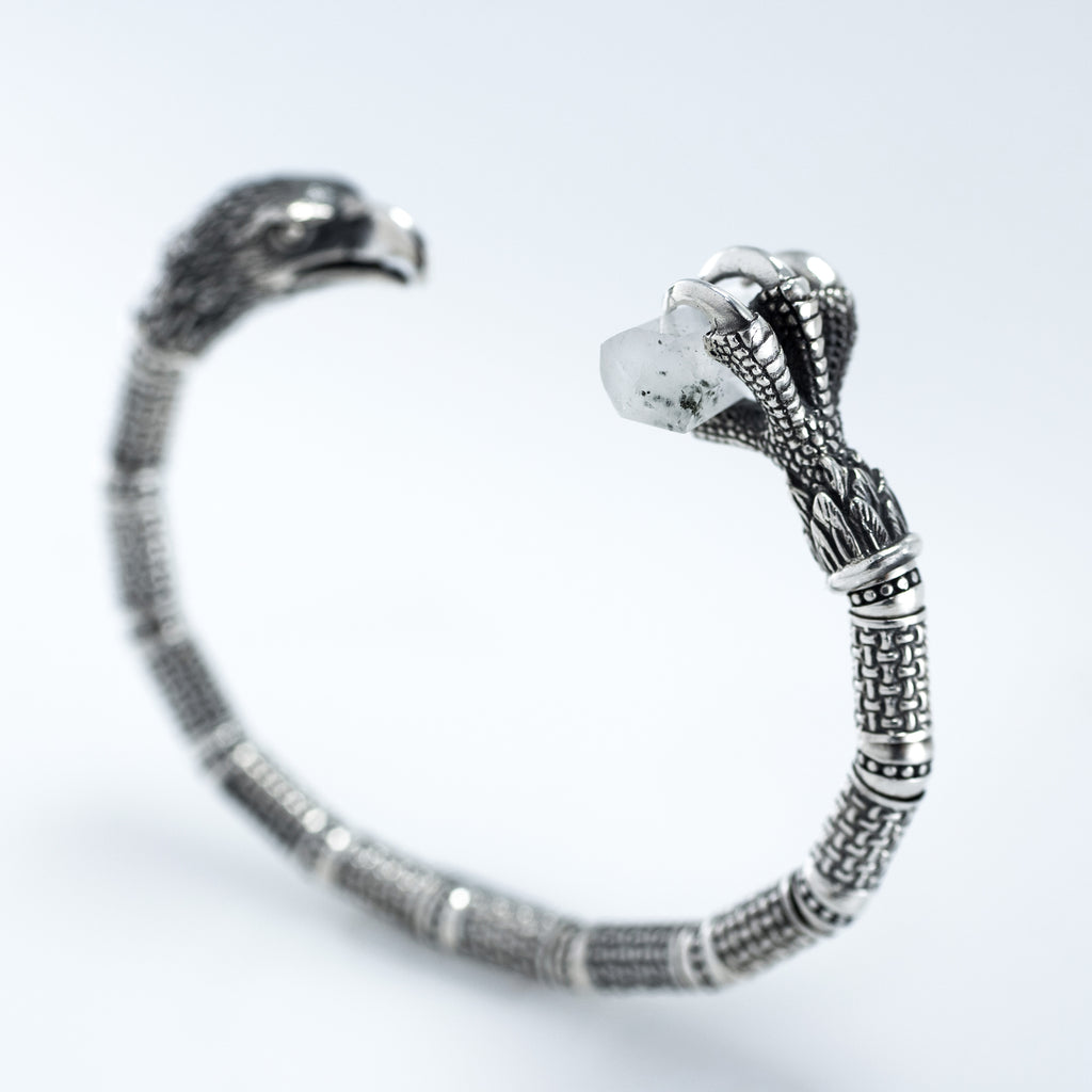 Eagle talon end of the silver cuff gripping a raw rock crystal