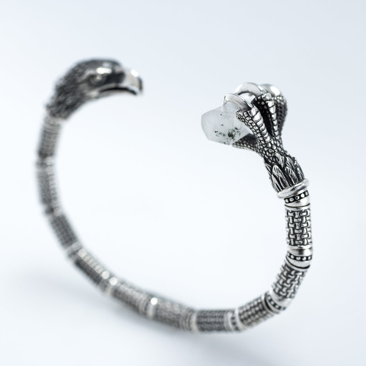 Eagle talon end of the silver cuff gripping a raw rock crystal